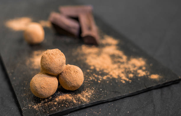 istock Chocolate truffle candy coated in cocoa powder against black background 823268846