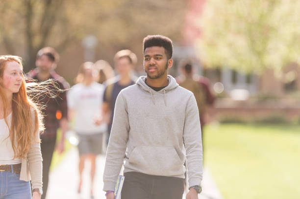 istock College students hang out in between classes on sidewalk, talking and smiling 823271740