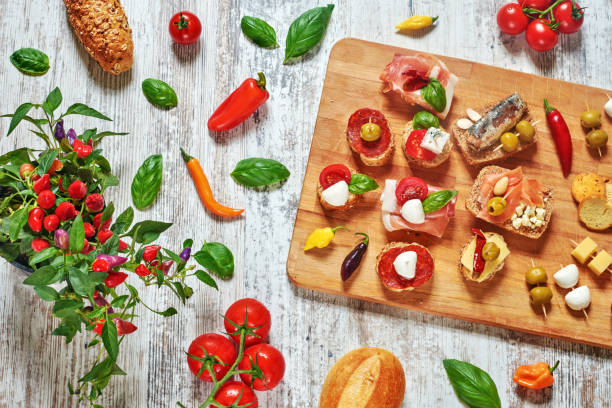 mix of appetizers / snacks. mediterranean tapas or antipasti on a rustic wooden table. - mozzarella tomato sandwich picnic imagens e fotografias de stock