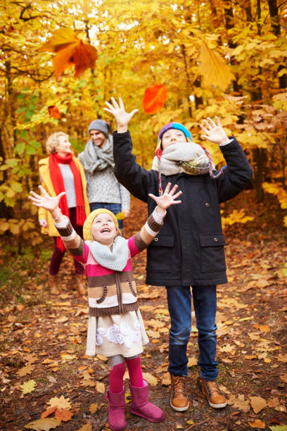 Cheerful children catching autumnal leafs