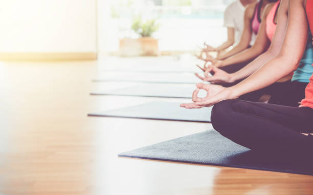 istock Close up hands of yoga group seated doing Hand Mudra and meditates in a training studio fitness room, Calm and relax concept,wellness and healthy lifestyle,leave space for adding text. 823280298