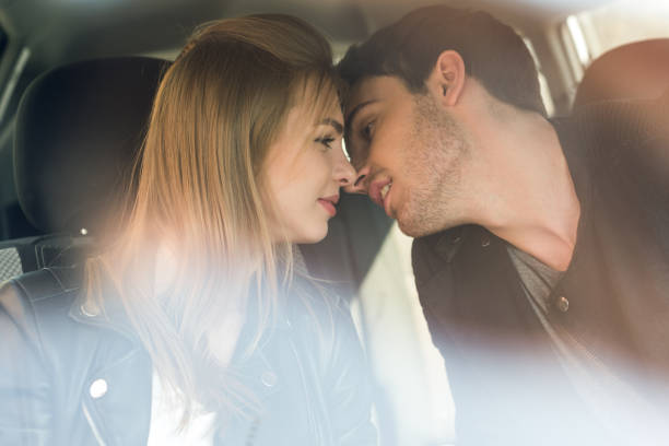 istock young man kissing beautiful girlfriend while sitting in car 823289548