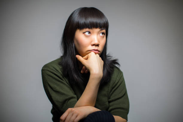 istock Thoughtful Woman Resting Against Gray Background 823297092