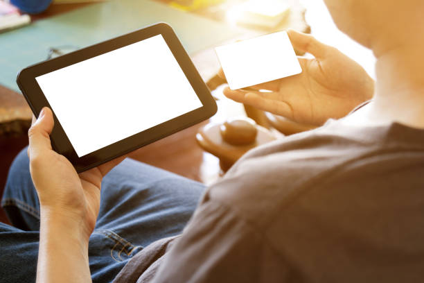 istock man holding credit card and using mobile tablet computer for online shopping 823307924