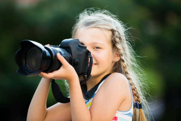 istock friendly female child taking pictures with camera in park 823311456