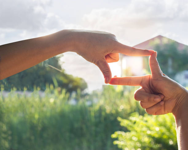 istock hands symbol with house in sunshine nature background 823315526