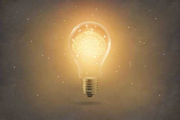 cerveau doré brillant à l’intérieur de l’ampoule sur fond de texture de papier - inventor photos et images de collection