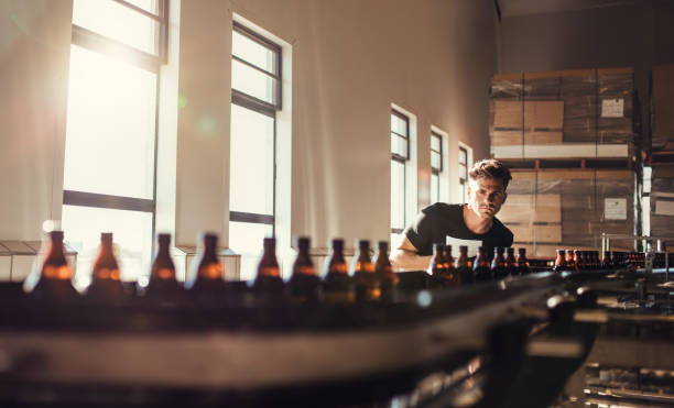 istock Brewer looking at conveyor with beer bottles 823318306