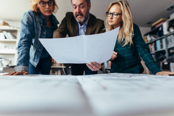 istock Group of architects over blueprints plans in office 823322562