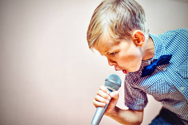 The child sings into the microphone stock photo