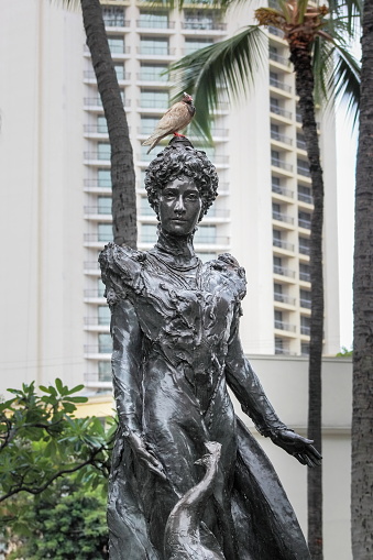Honolulu, Hawaii - May 27, 2016: Public art statue of Princess Victoria Kaiulani Cleghorn feeding her beloved peacocks located, in a small triangle park at the corner of Kuhio Avenue and Kanekapolei Street in Waikiki.