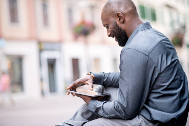 istock Businessman sitting on the bench and using digital tablet 823328116