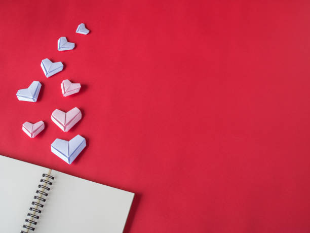 istock White paper hearts on red background. Valentine's Day background. 823336700