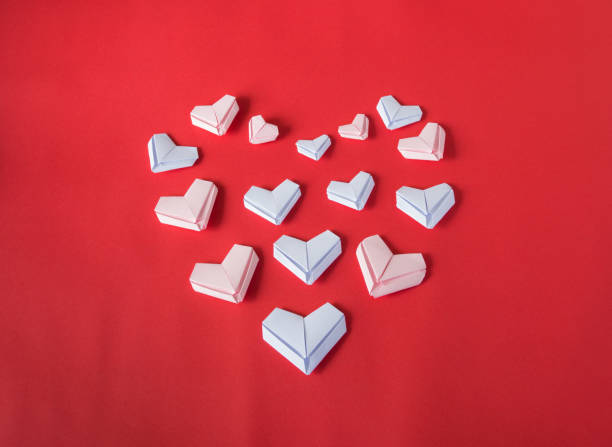 istock White paper hearts on red background. Valentine's Day background. 823339066