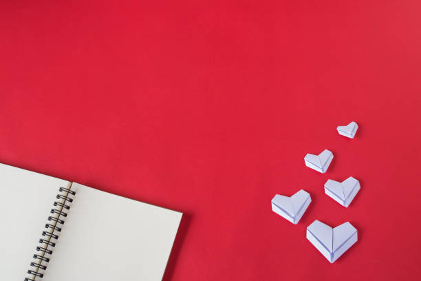 istock White paper hearts on red background. Valentine's Day background. 823339146