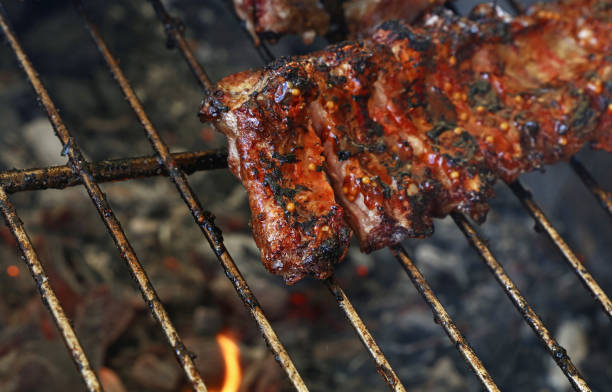 istock Rack of pork spare ribs on fire barbecue grill 823339570