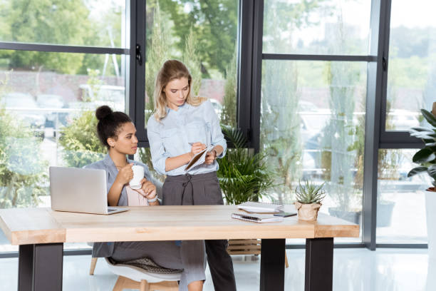 istock multiethnic businesswomen discussing new business project while sitting at workplace in office 823352904