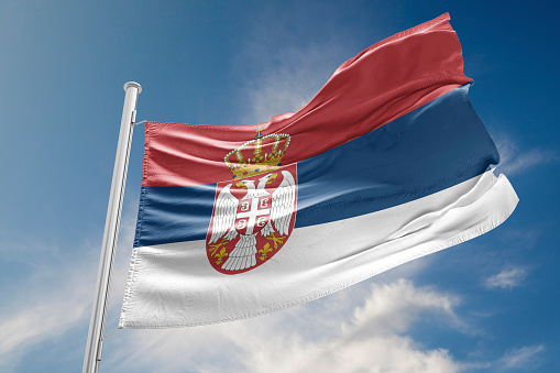 Serbia flag is waving at a beautiful and peaceful sky in day time while sun is shining. 3D Rendering