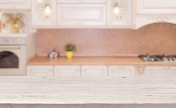 istock Blurred kitchen interior background with wooden planks table in front 823365066