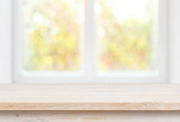 istock Wooden table top on blurred glass window wall building background 823365068