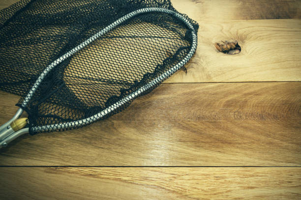 Spoon fishing net on old wooden table.