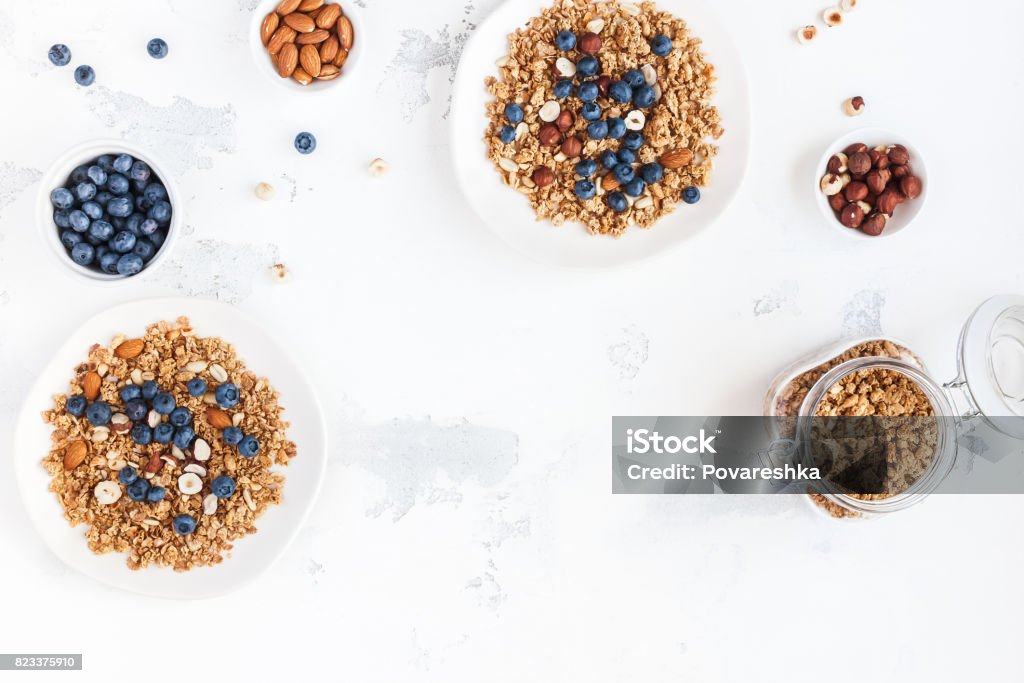 Breakfast with muesli, blueberry, nuts. Flat lay, top view Breakfast with muesli, blueberry, nuts on white background. Healthy food concept. Flat lay, top view, copy space Breakfast Stock Photo