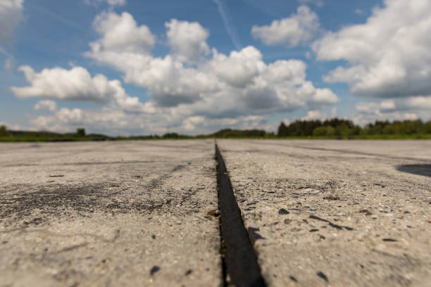 Old runway, tarmac road on a sunny day. Road tire with smudges from tires. Sunny cloudy day.