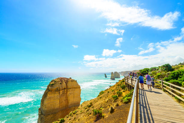 People walking along the Castle Rock, Twelve Apostles Port Campbell, Victoria: People walking along the Castle Rock pathway and enjoyong the view of Twelve Apostles on a bright day twelve apostles sea rocks victoria australia stock pictures, royalty-free photos & images