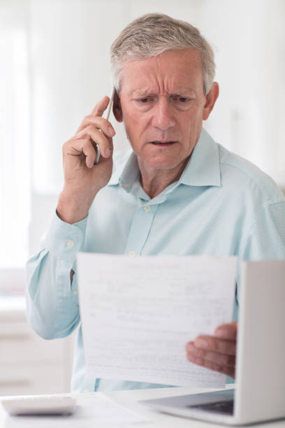 istock Unhappy Senior Man On Phone Querying Bill 823394724