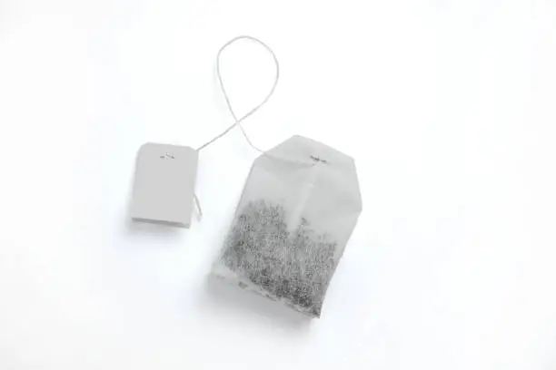 Photo of Teabag with grey label. Top view. Isolated on a white. mockup