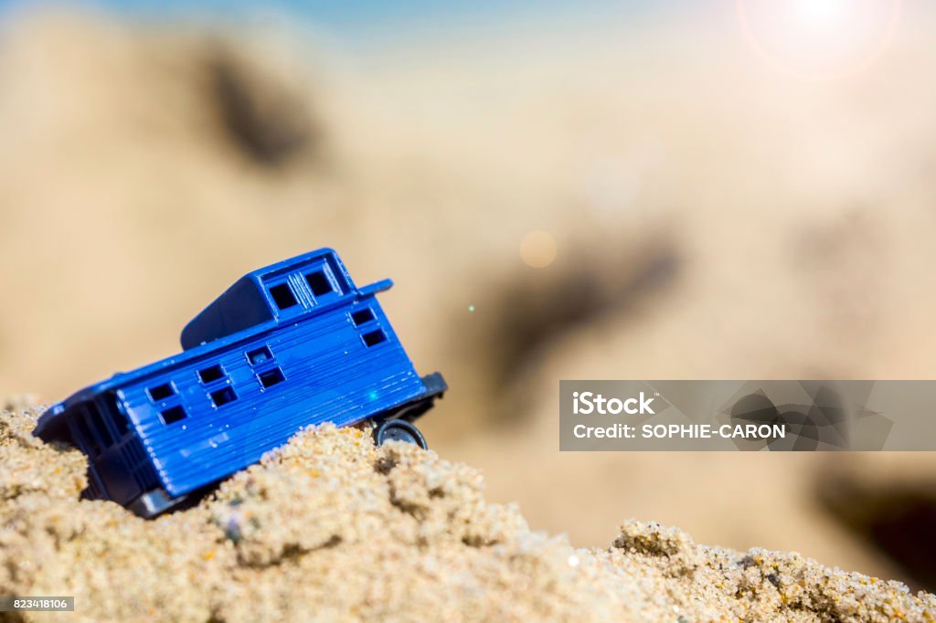 The little train A train-shaped toy on the sand Blue Stock Photo