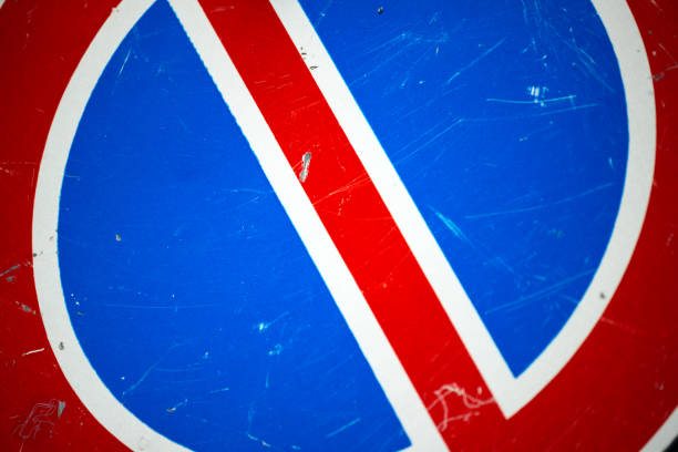 Red and blue prohibition signpost lying on the ground. Fallen road sign.