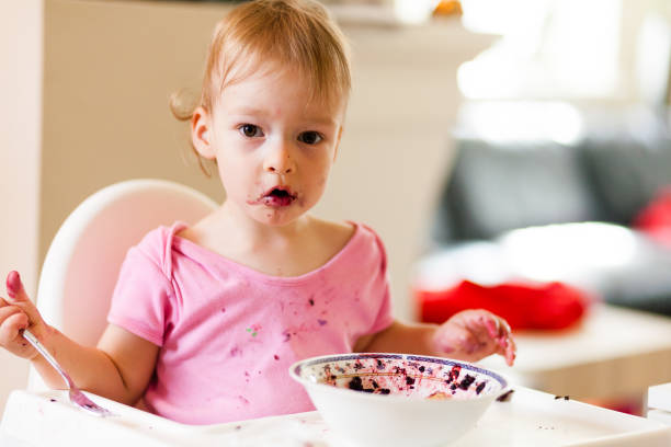 istock 2 years old girl child is eating 823429080