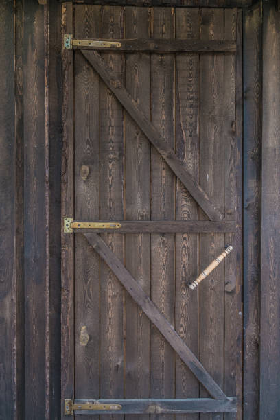 istock Countryside aged old farm barn door closeup 823433806