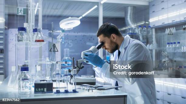 Research Scientist Looks Into Microscope Hes Conducts Experiments In Modern Laboratory Stock Photo - Download Image Now