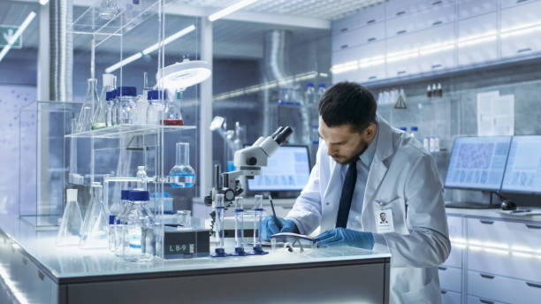 istock Research Scientist Writes Down Observations. He's Conducts Experiments in Modern Laboratory. 823447566