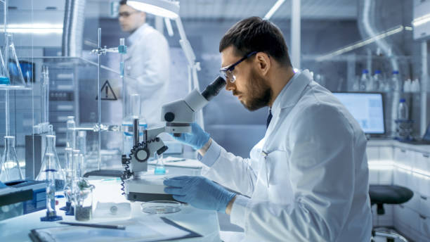 istock In a Modern Laboaratory Research Scientist Examines Substance Under Microscope. 823447704