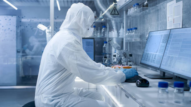 istock In a Secure High Level Laboratory Scientists in a Coverall Conducting a Research. Biologist Analyzes Results on a Computer. 823447786