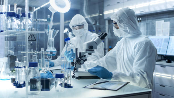 istock In a Secure High Level Laboratory Scientists in a Coverall Conducting a Research. Chemist Adjusts Samples and Discuss Experiment with Collegue. 823447810