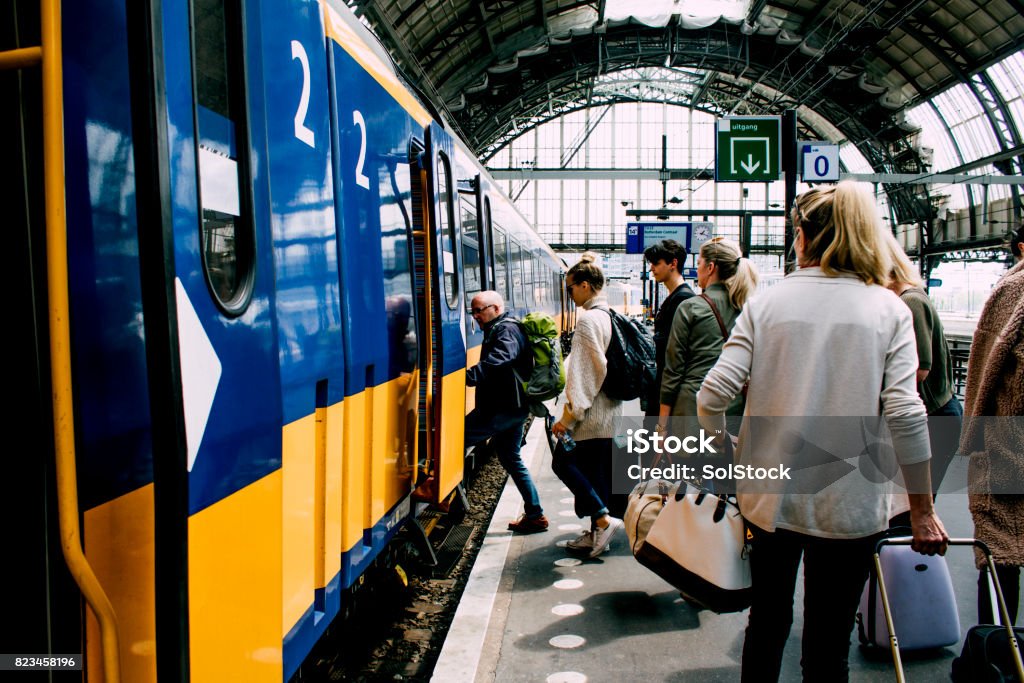 Friends Catching The Train In Amsterdam A group of friends getting on the train in Amsterdam. Train - Vehicle Stock Photo