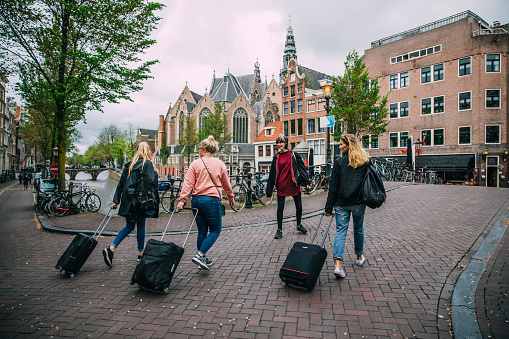 Female tourists in Amsterdam walking with their bags and suitcases