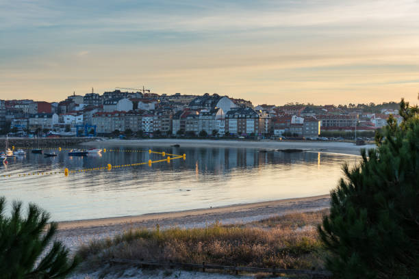Empty beach in the Rias Baixas in Galicia at the end of a rainy Summer day, with Portonovos in the background.