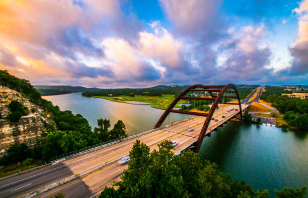 dramatic colorful clouds at golden hour pennybacker bridge at sunrise in austin , texas or 360 bridge overlook - town imagens e fotografias de stock