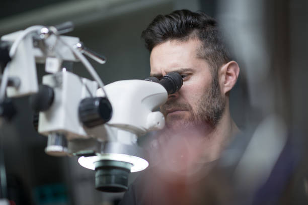 istock Professional gemstone settings jewellery craft laboratory: man working with microscope 823469988