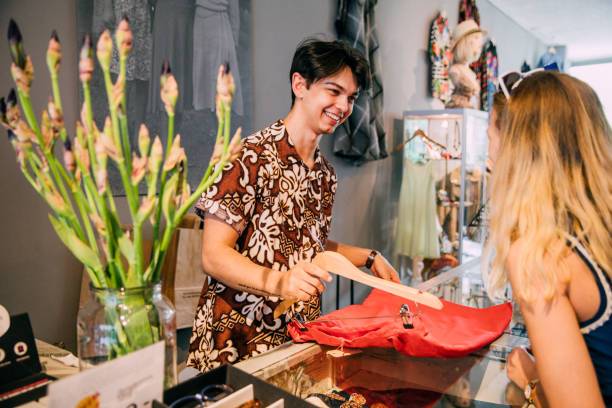 young salesman in a clothing store - owner boutique store retail imagens e fotografias de stock