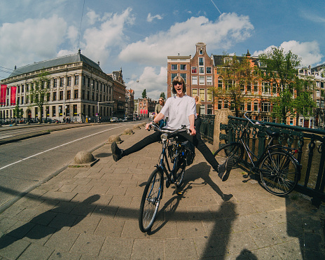 Young woman having fun on her bicycle while riding around the city of Amsterdam