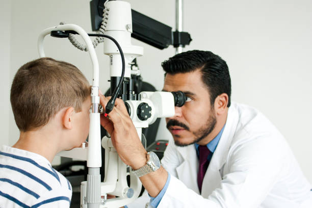 Oftamologo in your office ophthalmologist in his office, giving review. Sitting at the desk watching the computer eye test equipment stock pictures, royalty-free photos & images