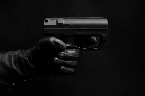 istock Black pistol, black leather gloves, black background 823492766