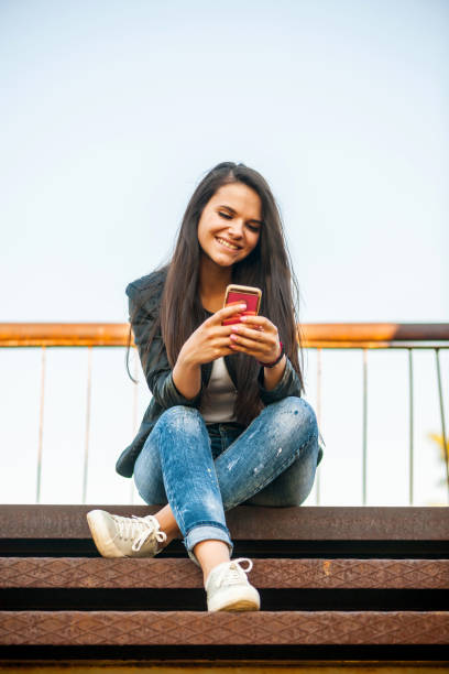 istock Smiling girl with phone 823497386