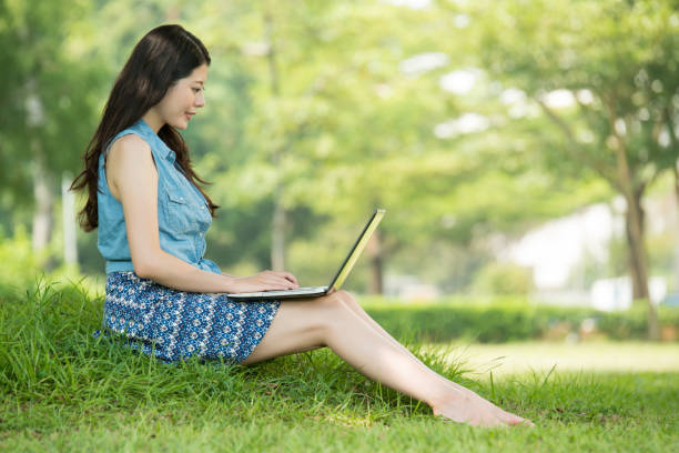 istock beautiful asian woman using computer in outdoor park 823501096